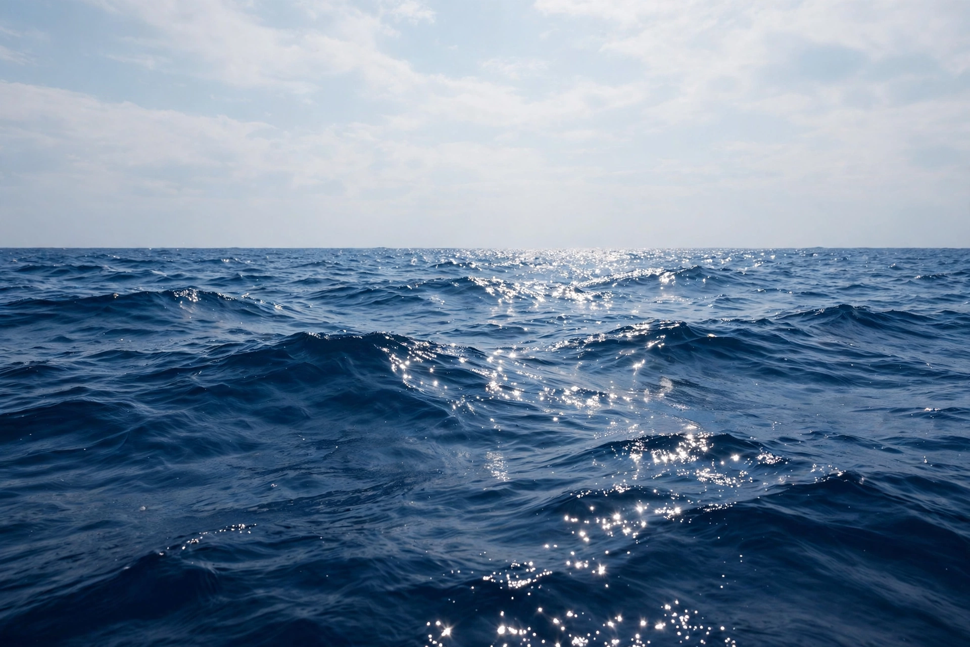 ocean quotes — deep blue open ocean with rolling waves under a soft sky